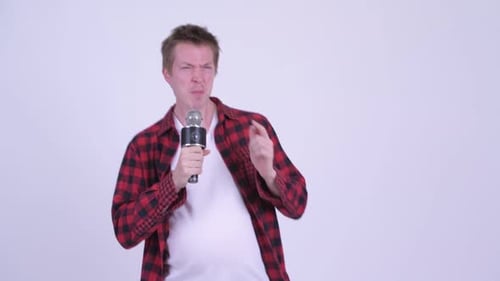 Feliz joven y gordo hipster con gran barriga cantando con micrófono