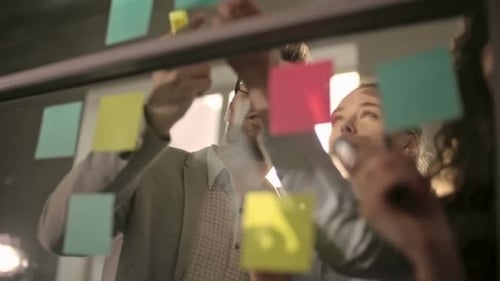 Team Brainstorming with Sticky Notes in Bright Office