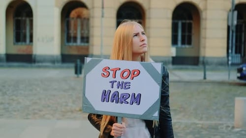 Une femme blonde proteste pour mettre fin au mal en tenant un bateau à vapeur