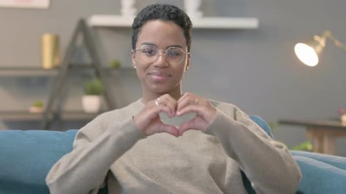 Woman Smiling and Making Heart Shape With Hands