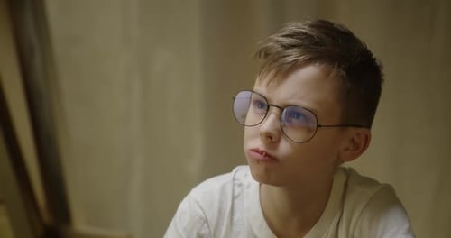 Boy Looking at Picture While Eating