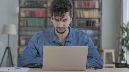 Man Leaving Office After Completing Work on Laptop