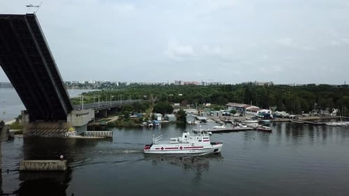 A medical ship sails under a raised bridge. the concept of water rescue. Drone aerial