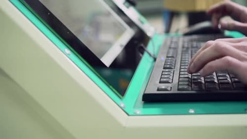 Die Hände des Mannes tippen auf der Tastatur des Maschinensteuerpults