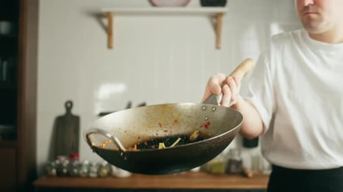Chef Tossing Noodles and Vegetables in a Wok