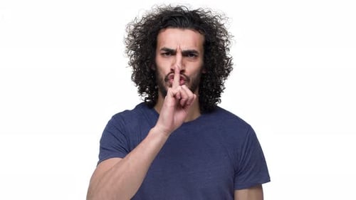 Porträt eines unrasierten kaukasischen Mannes, der mit strengem Blick posiert und darum bittet, Ruhe zu bewahren und Index zu setzen