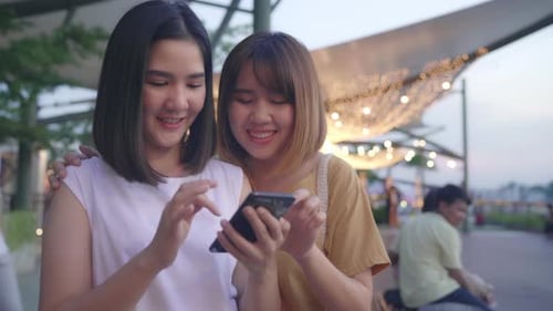 Asia women tourist with casual style look at photo on smartphone screen on mobile phone with river.