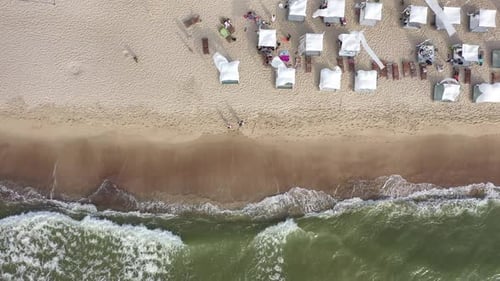 AERIAL: Top Shot of White Tents on Sandy Beach on a Sunny Windy Day