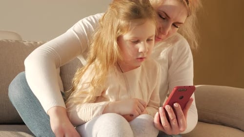 Child and Woman Watching Red Smartphone