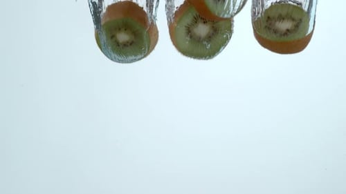 Kiwi Fruit Slices Falling into Water