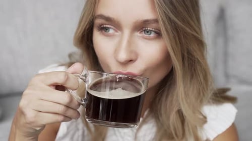 Young Adult Woman Drinks Coffee at Home
