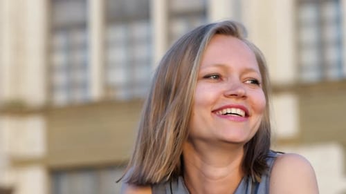 Blonde Woman Smiles in Urban Setting