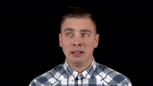 A Young Man Shows an Emotion of Fear on His Face. A Person Experiences Fear. A Man in a Shirt on a
