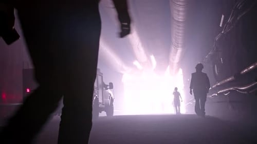 Silhouette vieler Bauarbeiter, die aus einem großen Tunnel herauskommen