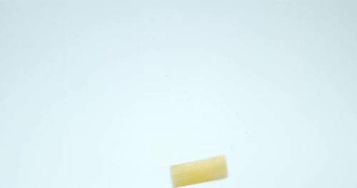 Dry Pasta Cannelloni Falls Under Water with Air Bubbles