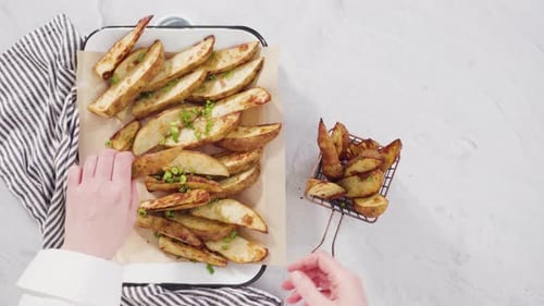Flat lay. Freshly baked potato wedges with spices on a white serving tray