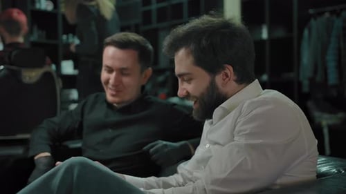 Two Men Smiling and Talking Indoors