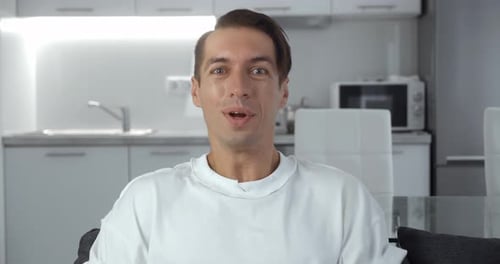 Excited young man celebrating success in modern kitchen