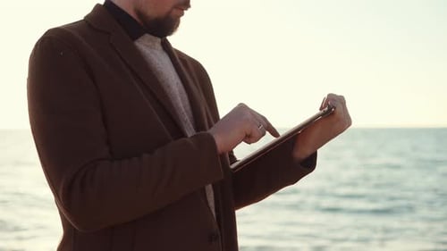 Hombre con tableta en la playa