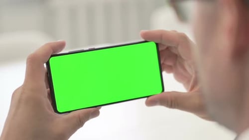 Man using Smartphone with Green Chroma Screen