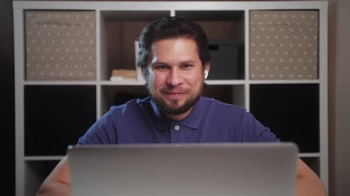 Lächelnder junger Mann, der mit Freunden spricht, Live-Videokonferenz macht Online-Chat mit dem Laptop zu Hause