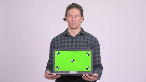 Man Holds Laptop with Green Screen Mockup