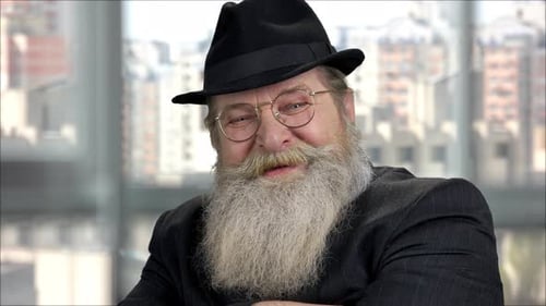 Closeup Portrait of an Old Bearded Smiling Man with Black Hat and Suit
