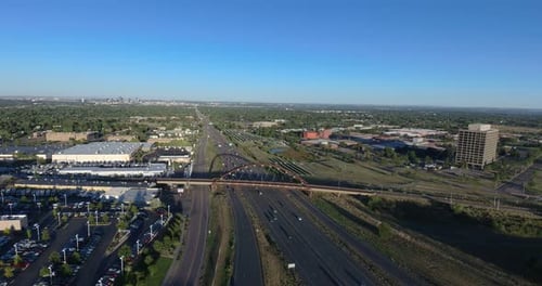 An evening pan over 6th Avenue, Lakewood Colorado. We capture a light rail train as the Denver skyl