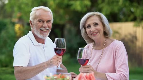 Smiling Old Couple Celebrating Anniversary With Wine Glasses, Family Traditions