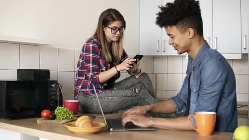 Young Couple Using Technology in Kitchen