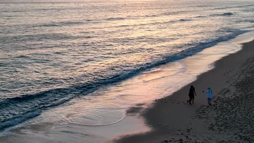 People sit on the beach and watch the sunset