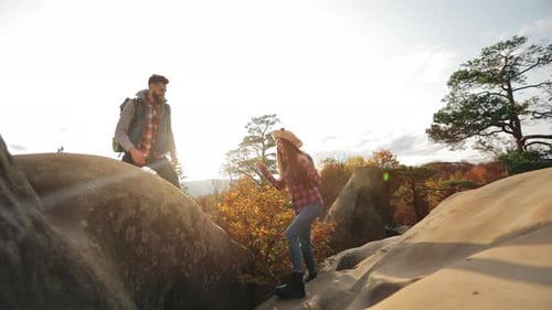A Young Woman is Climbing a Cliff