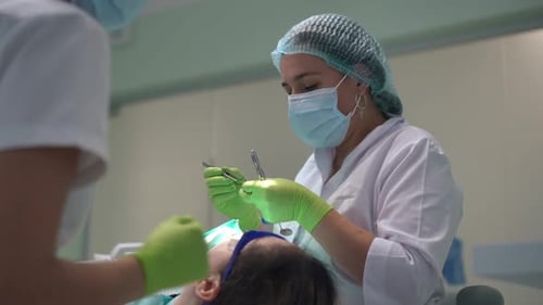 Dentist and Assistant Perform Delicate Dental Work