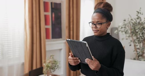 Woman Using Tablet in New Home with Boxes