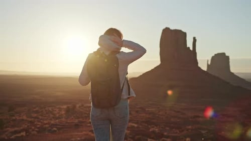Naturhintergrund: Reisende, Frau mit Rucksack, Monument Valley bei Sonnenuntergang, USA