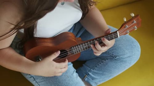 Woman Plays Ukulele in Relaxed Setting