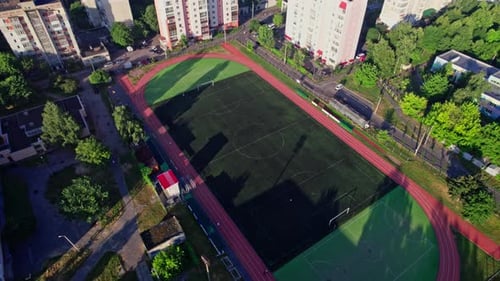 Buildings with Street in Small Town with Empty Football Soccer Field