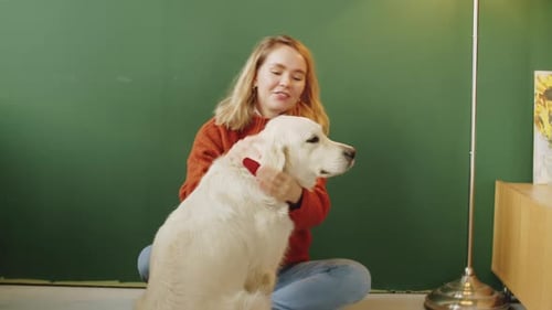 Woman Petting Her Dog Sitting on the Floor
