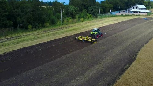 Tractor Plows The Field. Tractor with cultivator handles field before planting