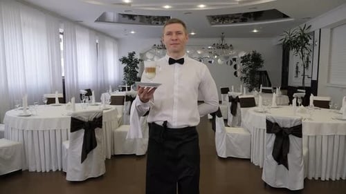 Man in Apron Carrying Tray with Cup of Latte for Customer in Cozy Cafeteria