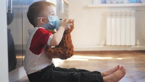 Child Wearing Mask Puts Mask on Teddy Bear