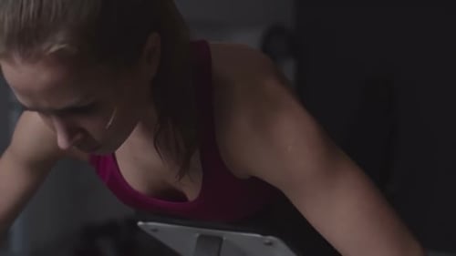 Woman Works Out on Prone Bench Row Machine