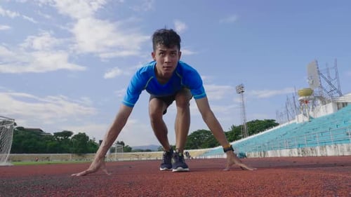 Young Adult Athlete Running Fast on Outdoor Track