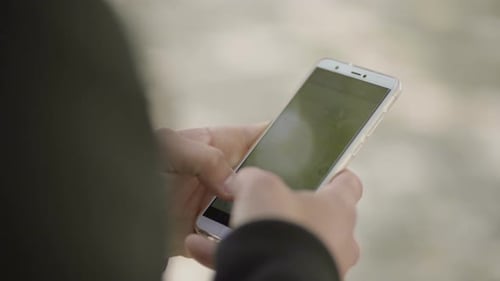 Person Using Cell Phone in Urban Setting