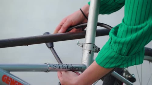 Hands Locking Bike to a Rack