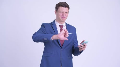 Businessman Reacting Negatively to Something on Phone