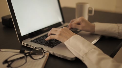 Hands Typing on Laptop at Desk Close Up
