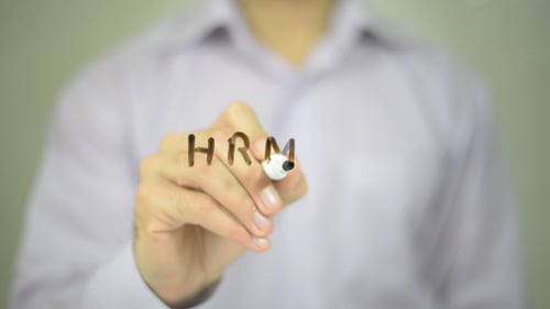 Man Writing HRM in a Workplace Close Up