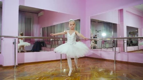 Ballerina dancing in studio in front of mirror. In the ballet hall. A little dancer. Slow motion.