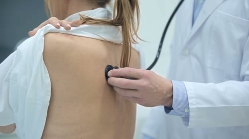 Doctor Examining Patient's Back With Stethoscope